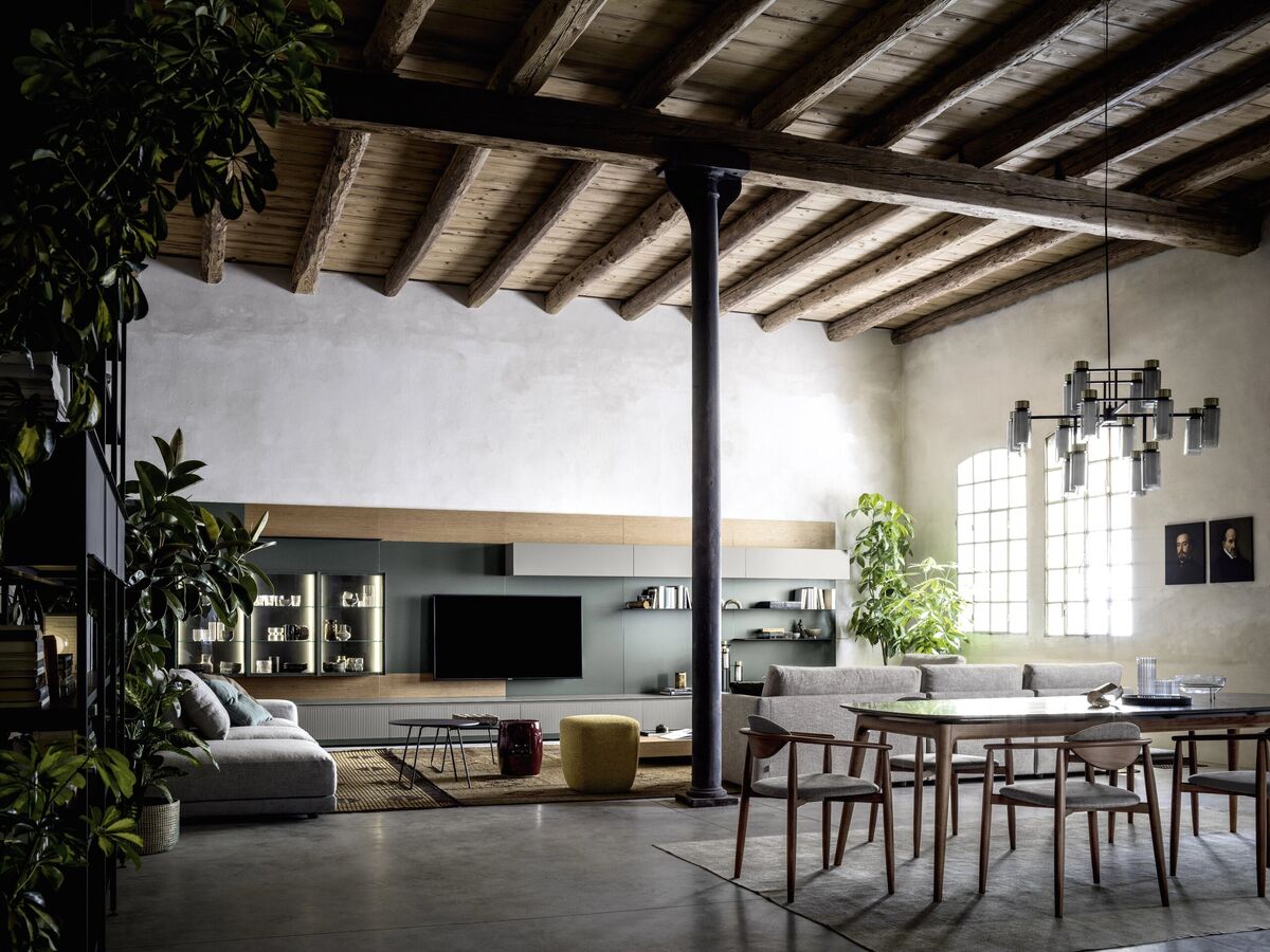 Loft mit Wohnbereich und Esstisch unter Holzbalkendecke